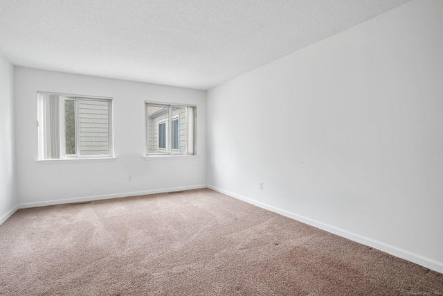 unfurnished room featuring carpet floors, baseboards, and a textured ceiling