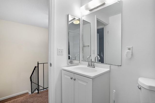 bathroom featuring vanity, toilet, and baseboards