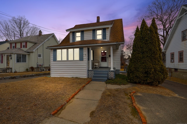 view of front of property with covered porch and a shingled roof