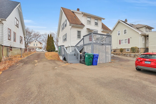 view of front of property with a shingled roof and fence