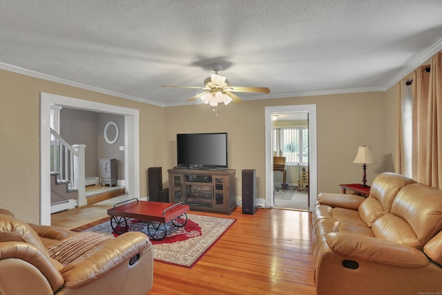 living room featuring light wood-type flooring, crown molding, stairway, and baseboard heating