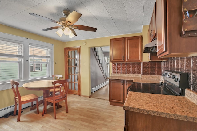 kitchen featuring electric range, decorative backsplash, a baseboard radiator, light wood-type flooring, and exhaust hood