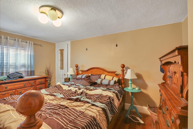 bedroom with a textured ceiling, wood finished floors, and baseboards