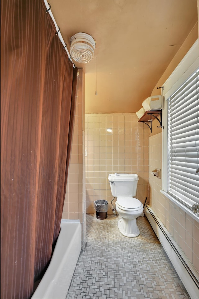 full bath with toilet, a baseboard heating unit, a wainscoted wall, tile walls, and shower / bath combo