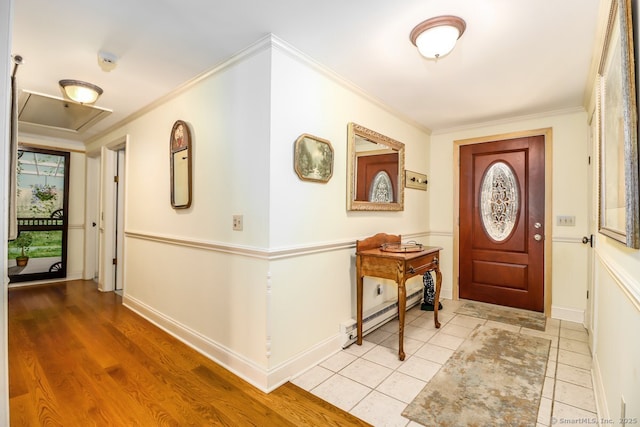 tiled foyer entrance featuring a baseboard heating unit, crown molding, and baseboards