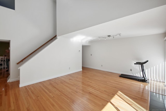 bonus room with light wood-style floors, baseboards, and stairs