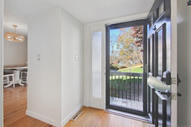 entryway with a healthy amount of sunlight, visible vents, baseboards, and wood finished floors