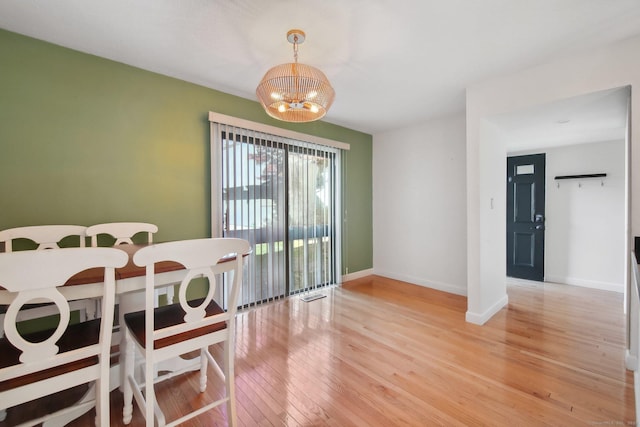 dining area featuring light wood-type flooring, baseboards, visible vents, and a chandelier