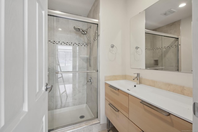 full bath with vanity, a shower stall, and visible vents