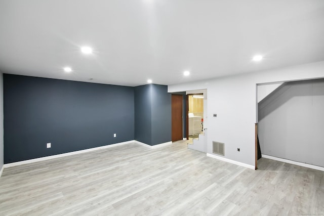 finished below grade area featuring light wood finished floors, recessed lighting, visible vents, and baseboards