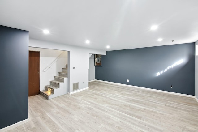 finished basement featuring recessed lighting, visible vents, light wood-style flooring, baseboards, and stairs