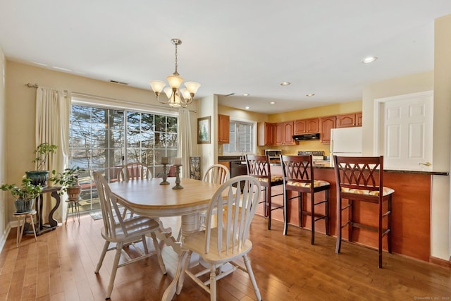 dining space with an inviting chandelier, light wood-style flooring, and recessed lighting