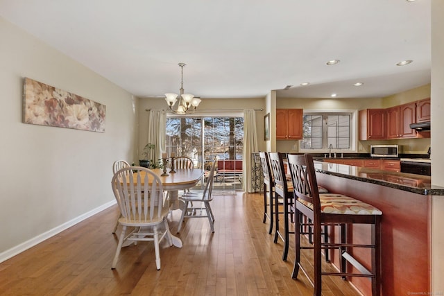 dining space with recessed lighting, a notable chandelier, baseboards, and light wood-type flooring