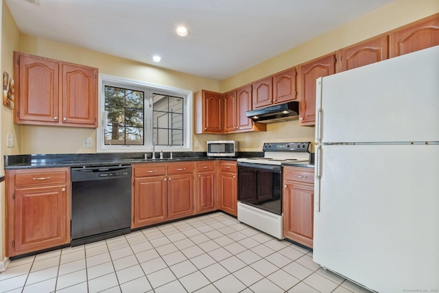 kitchen with under cabinet range hood, a sink, dark countertops, recessed lighting, and white appliances