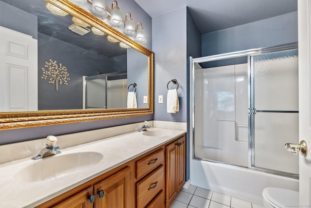 full bath featuring tile patterned floors, double vanity, shower / bath combination with glass door, and a sink