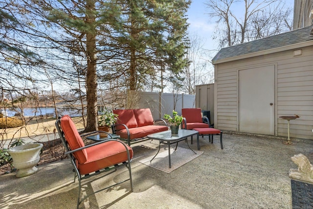 view of patio / terrace with outdoor lounge area, fence, and a water view