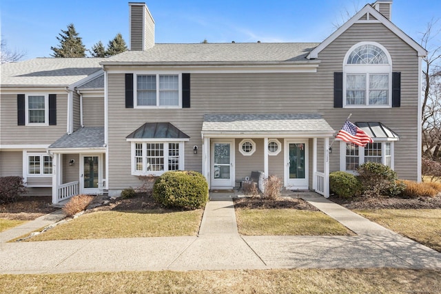 multi unit property with a front lawn, a chimney, french doors, and roof with shingles