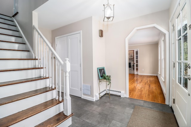 foyer entrance with stairs, baseboards, and arched walkways