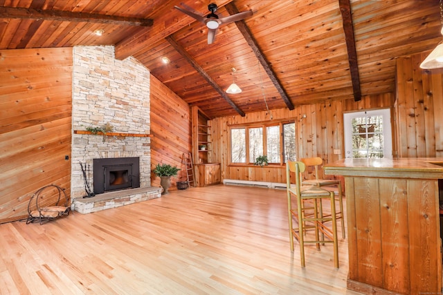 unfurnished living room with wood ceiling, wooden walls, beam ceiling, and a healthy amount of sunlight