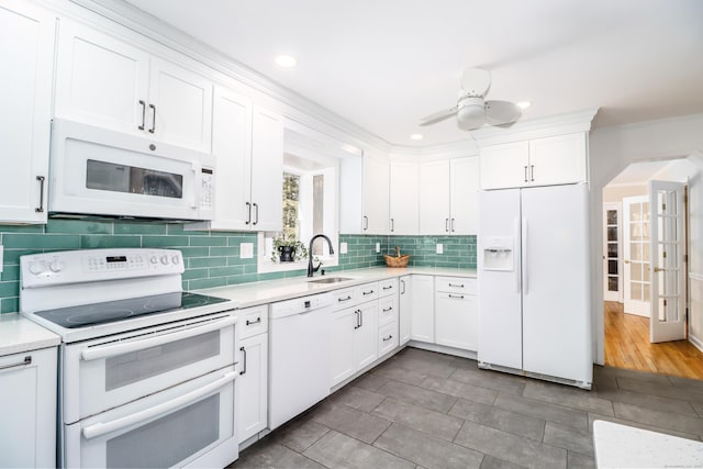 kitchen featuring white appliances, a ceiling fan, white cabinetry, light countertops, and tasteful backsplash