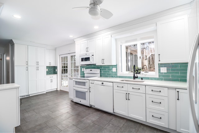 kitchen featuring light countertops, white appliances, a sink, and a healthy amount of sunlight