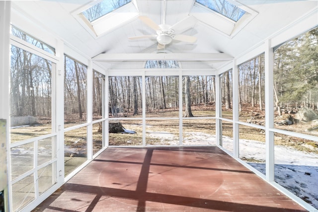 unfurnished sunroom with lofted ceiling with skylight and a ceiling fan