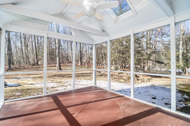 unfurnished sunroom with lofted ceiling with skylight and a ceiling fan