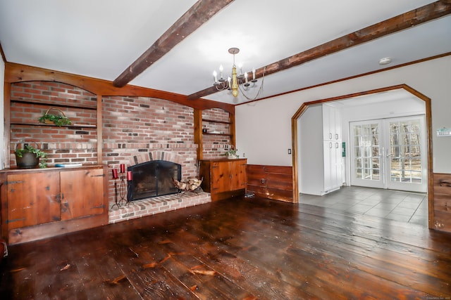 living room with french doors, hardwood / wood-style floors, beamed ceiling, and a brick fireplace