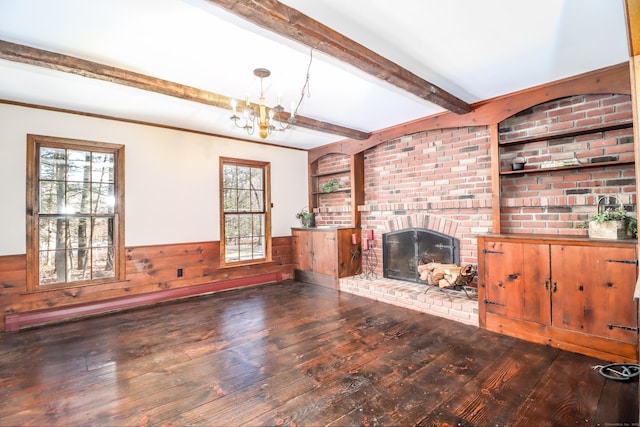 unfurnished living room with a wainscoted wall, hardwood / wood-style flooring, a fireplace, and beam ceiling