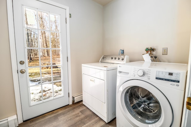 washroom featuring baseboard heating, laundry area, washing machine and clothes dryer, and wood finished floors