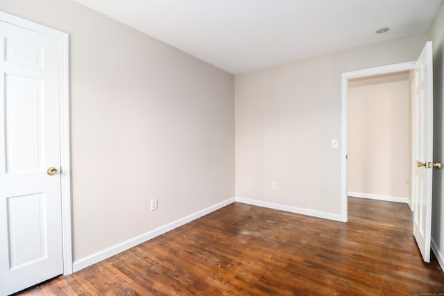 unfurnished bedroom with dark wood-style flooring and baseboards