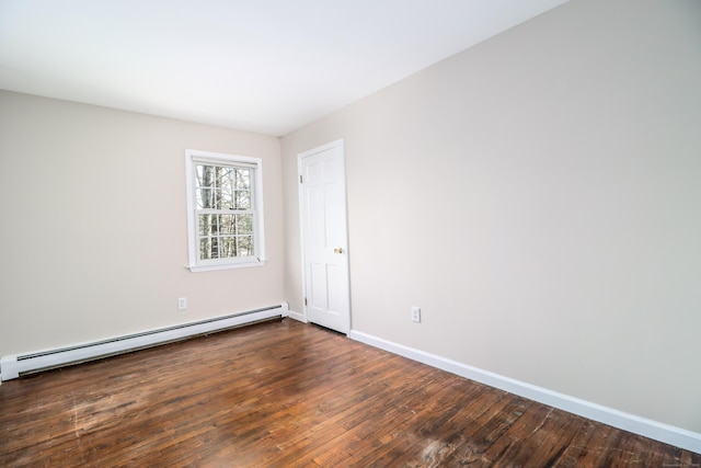 spare room featuring wood-type flooring, baseboards, and baseboard heating