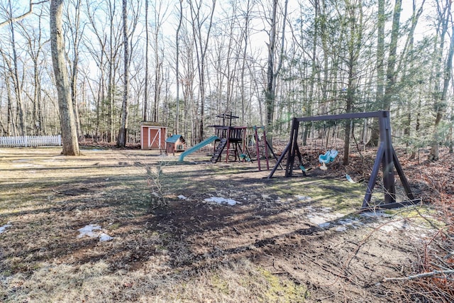 view of play area featuring an outdoor structure and a wooded view