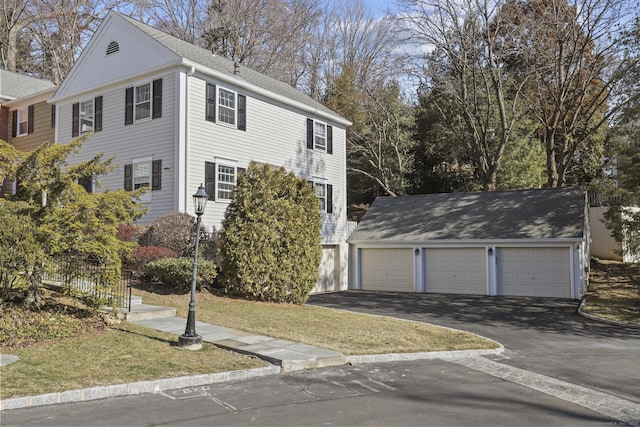 view of front of home featuring a shingled roof, an outdoor structure, and a detached garage