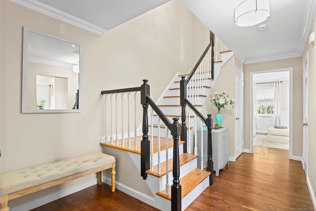 stairway featuring baseboards, ornamental molding, and wood finished floors