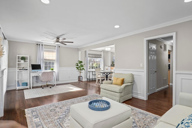 living area with a ceiling fan, ornamental molding, a wealth of natural light, and wood finished floors