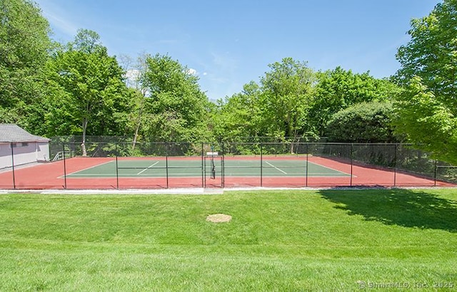 view of sport court featuring a lawn and fence