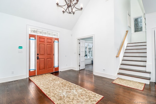 foyer with high vaulted ceiling, dark wood finished floors, baseboards, and stairs