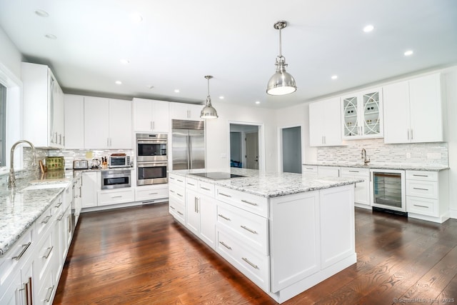 kitchen featuring wine cooler, dark wood finished floors, stainless steel appliances, a kitchen island, and a sink