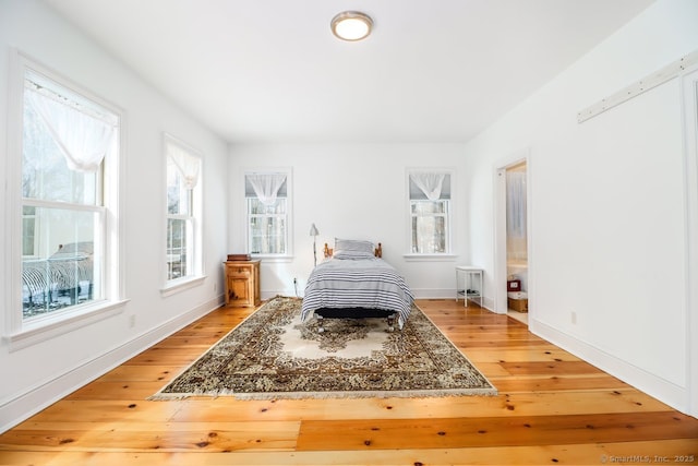 bedroom with light wood-style flooring and baseboards