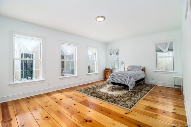 bedroom with wood-type flooring and baseboards