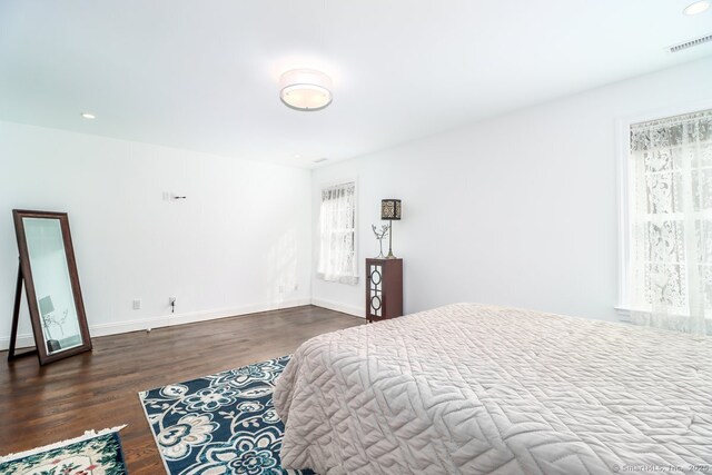 bedroom with baseboards, visible vents, wood finished floors, and recessed lighting