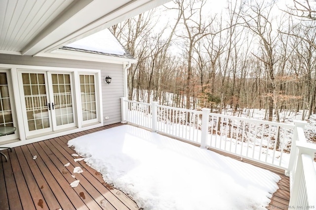 snow covered deck featuring french doors