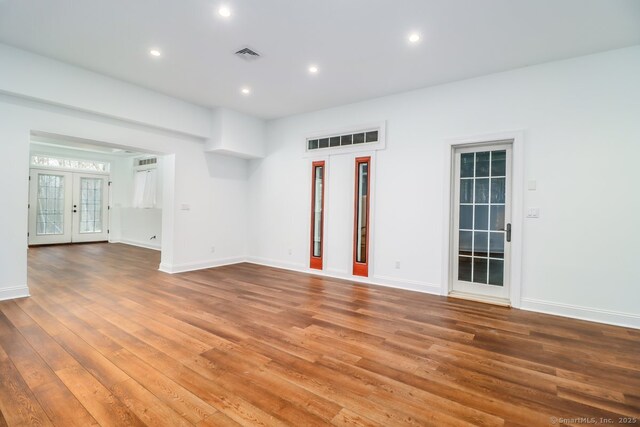 unfurnished room featuring baseboards, visible vents, wood finished floors, french doors, and recessed lighting