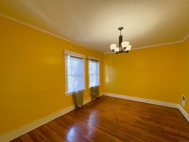 unfurnished room featuring an inviting chandelier, wood-type flooring, ornamental molding, and baseboards