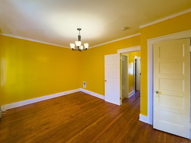 spare room featuring baseboards, ornamental molding, and dark wood finished floors