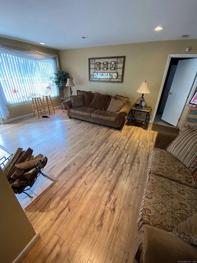 living room featuring baseboards, wood finished floors, visible vents, and recessed lighting