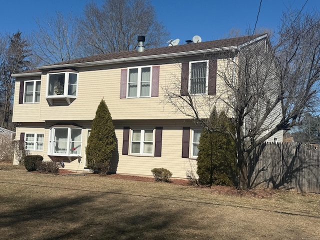 colonial home featuring fence