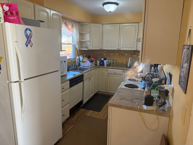 kitchen featuring white appliances, white cabinets, wood finished floors, open shelves, and a sink