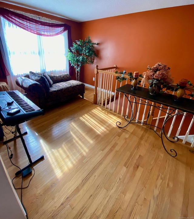 living area with baseboards and wood finished floors